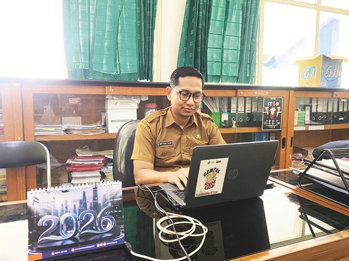 KEBIJAKAN: Analis Kebijakan Ahli Bagian Perekonomian dan SDA Setkab Sampang Muda Abdi Barri Salam saat melihat data laporan di kantor pemda Senin (19/1). (AYU LATIFAH/JPRM)