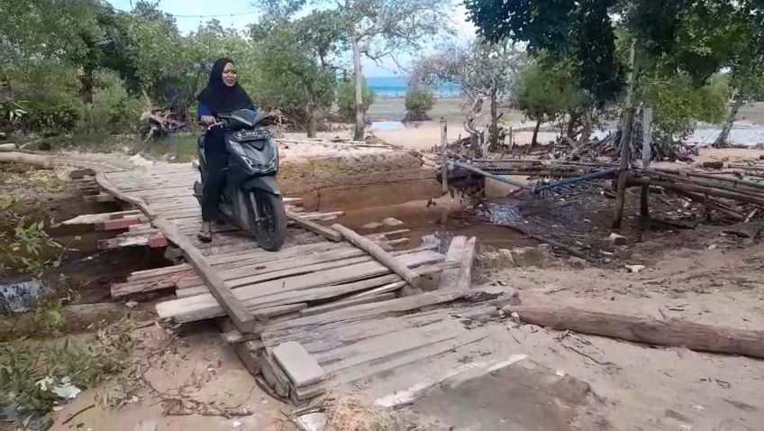 BUTUH PERBAIKAN: Pengendara motor berhati-hati saat melintasi jembatan alternatif di Desa Bringsang, Kecamatan Gili Genting.
