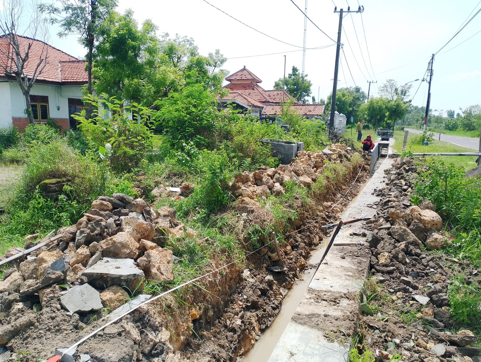 RUSAK: Tukang berada di sekitar pembangunan proyek BK Drainase yang rusak di Desa Apaan, Kecamatan Pangarangan, Rabu (26/11/2025).