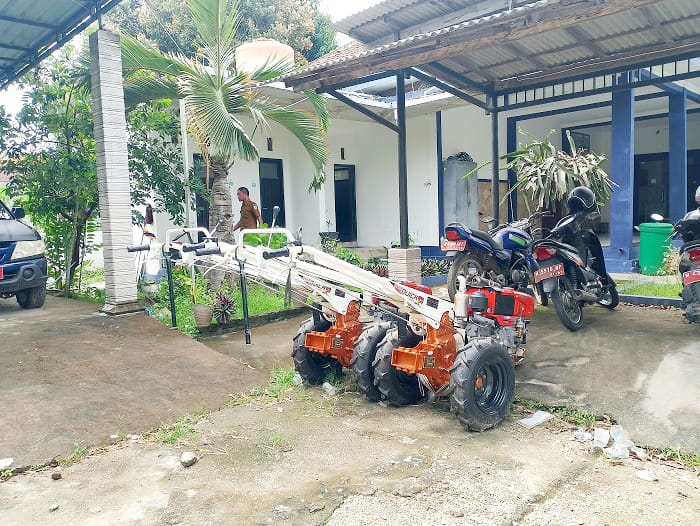 TIDAK DISALURKAN: Pegawai Disperta KP Sampang berada di sekitar dua mesin hand tractor yang belum disalurkan di halaman belakang kantor Selasa (20/1). (UBAIDILLAHIR RAIE/JPRM)