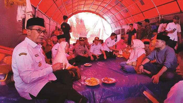 MERAKYAT: Bupati KH Kholilurrahman dan Wabup Sukriyanto berdialog dengan warga di pengungsian korban bencana tanah bergerak di Desa Sana Daja, Pasean, Pamekasan, Rabu (21/1). (M. KHOLIL RAMLI/JPRM)