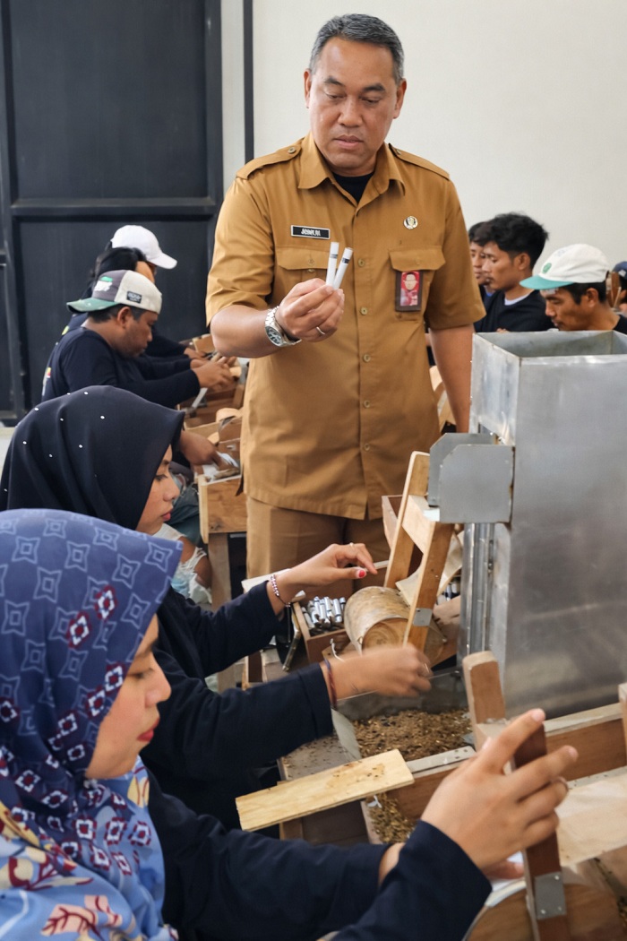 GIAT: Puluhan pekerja pabrik rokok sedang melinting di salah satu IHT yang beroperasi di Kecamatan Blega beberapa waktu lalu. (DISPERINAKER BANGKALAN UNTUK JPRM)