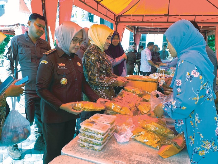 PEDULI UMKM: Kajari Sampang Fadilah Helmi saat membeli dagangan pedagang saat digelar bazar murah di halaman kantornya, Kamis (28/8/2025). (UBAIDILLAHIR RAIE/JPRM)