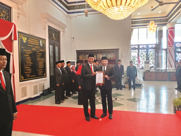 SAH: Dari kanan, Bupati Slamet Junaidi menyerahkan surat keputusan (SK) kepada Kepala Dispendik Nor Alam di Peringgitan Pendopo Trunojoyo, Sampang, Jumat (23/1). (UBAIDILLAHIR RAIE/JPRM)