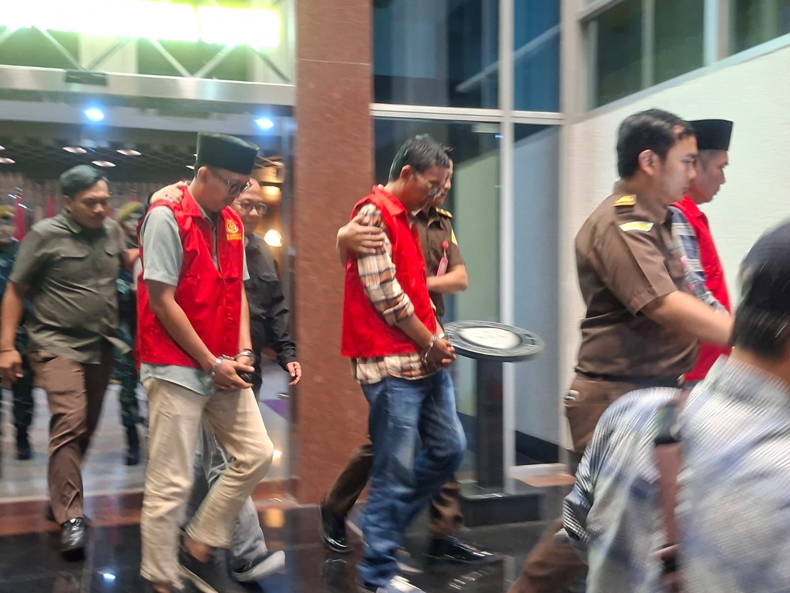 TAK BERKUTIK: Kejati Jatim saat menggiring keempat tersangka korupsi BSPS di kantornya, pada Selasa (14/10/2025) malam.