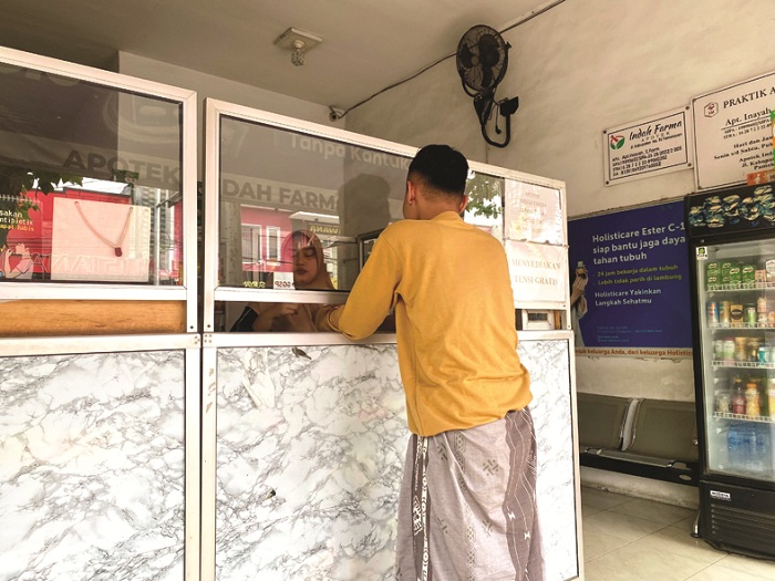 IKHTIAR SEHAT: Warga membeli obat di salah satu apotek di Pamekasan Jumat (23/1). (MOH. IQBAL AFGANI/JPRM)