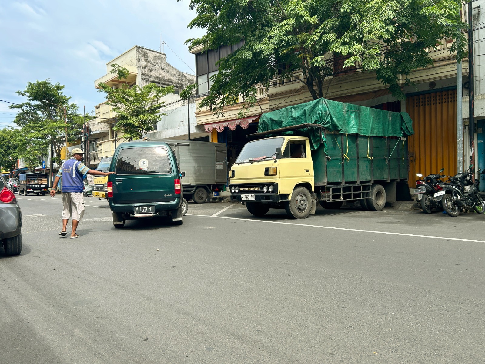 TAK OPTIMAL: Juru parkir di Jalan Raya KH Moh. Kholil Bangkalan tengah mengawal kendaraan, Sabtu (24/1). (VIVIN AGUSTIN HARTONO/JPRM)