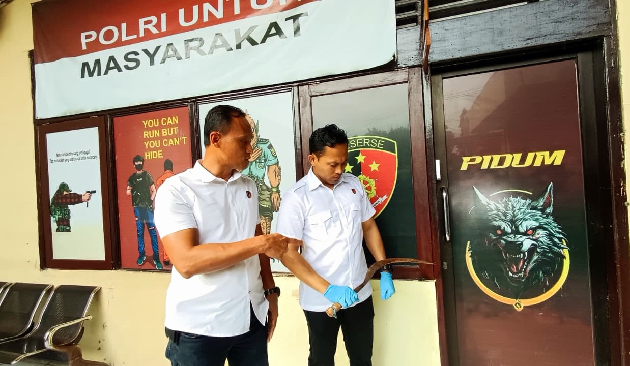 SAJAM: Kasatreskrim Polres Bangkalan AKP Hafid Dian Maulidi menunjukkan celurit yang digunakan Fauzi membacok Salam, Rabu (21/1). (ZEINAL ABIDIN/JPRM)
