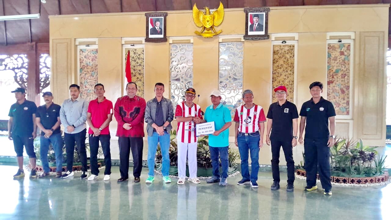 SIMBOLIS: Bupati Pamekasan KH Kholilurrahman menyerahkan reward kepada tim Persepam Pamekasan di Pendopo Ronggosukowati Sabtu (24/1). (M. KHOLIL RAMLI/JPRM)