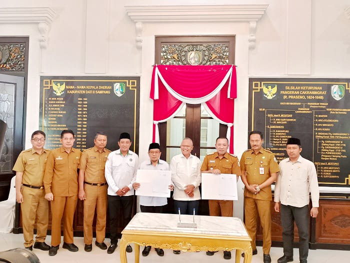 JALIN KERJA SAMA: Bupati Slamet Junaidi dan Kepala Kemenag Sampang Fandi menunjukkan nota MoU yang sudah ditandatangani di Peringgitan Pendopo Trunojoyo, Senin (26/1). (UBAIDILLAHIR RAIE/JPRM)