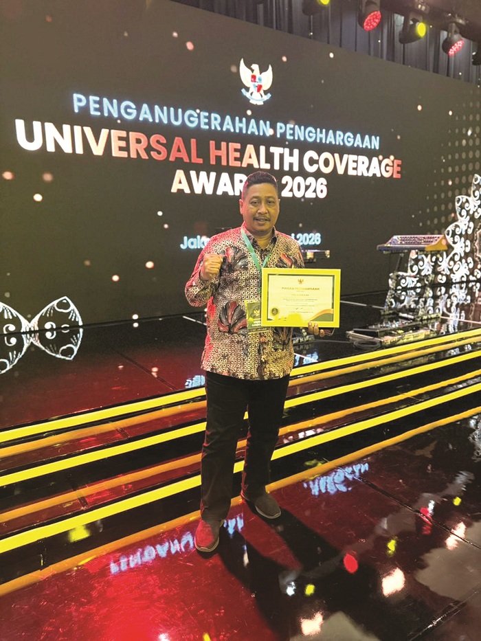 DIAPRESIASI: Sekkab Ismet Effendi menunjukkan trofi dan piagam penghargaan UHC Awards yang didapat Pemkab Bangkalan di JIExpo Kemayoran, Selasa (27/1). (PROKOPIM UNTUK JPRM)