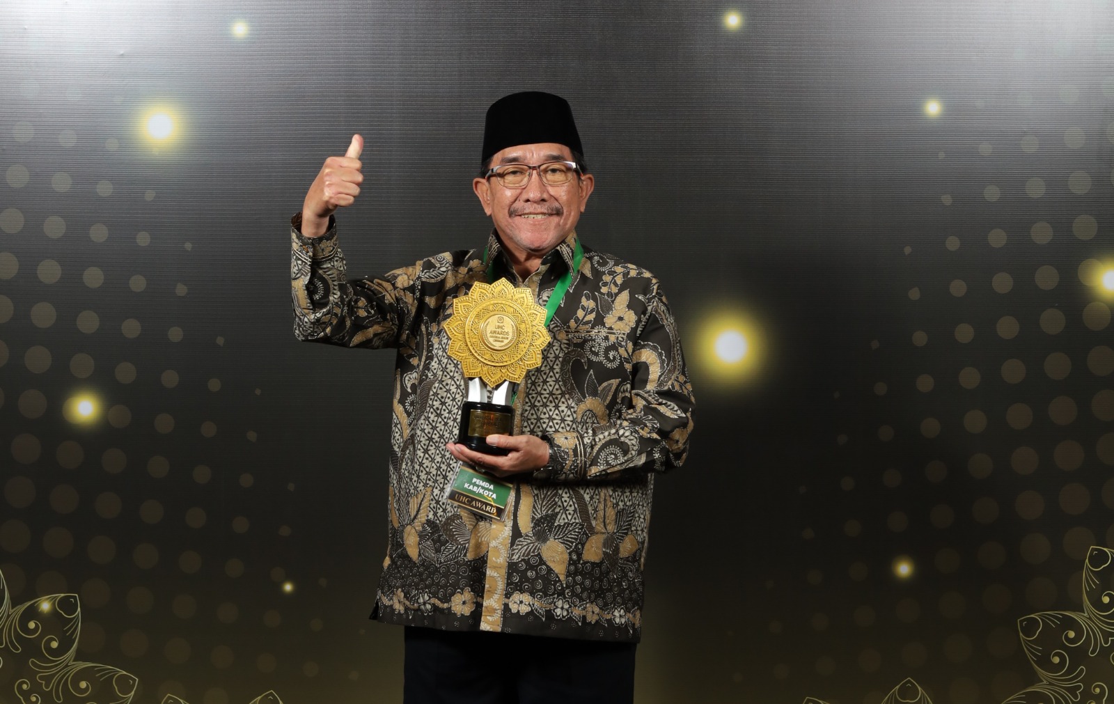 Wakil Bupati Sumenep KH. Imam Hasyim memegang piala UHC Awards 2026 di Jakarta.