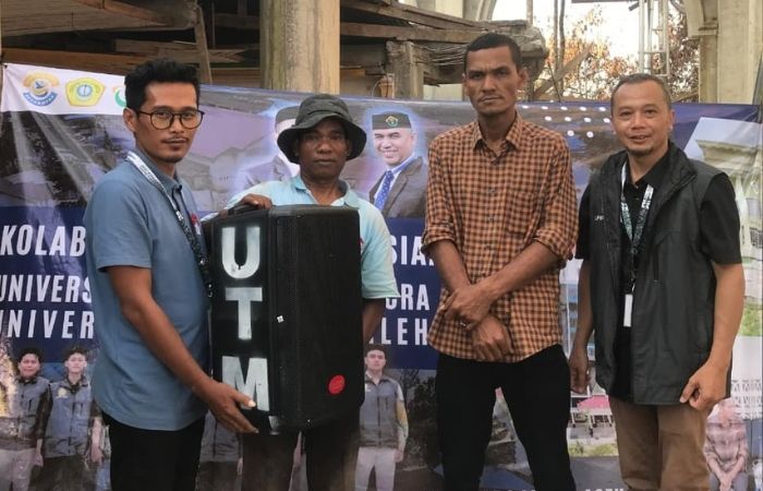 SEMOGA BERMANFAAT: Dosen Pendamping Lapangan (DPL) KKNT Kemanusiaan Ansori dan Haryo Triajie menyalurkan bantuan kepada pengurus masjid di desa Paya Rabu Lhok, Jumat (30/1).