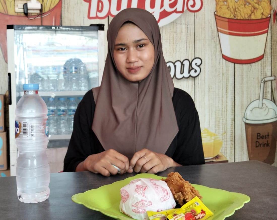 BIKIN NAGIH: Seorang remaja bersiap menyantap ayam goreng krispi di outlet Fidi Geprek Jalan Trunojoyo, Sampang.