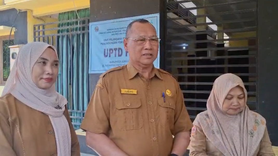 INTENS LALUKAN PENDAMPINGAN: Kepala Dinas Keluarga Berencana Pemberdayaan Perempuan dan Perlindungan Anak (KB PPPA) Bangkalan Sudiyo (tengah) memberikan keterangan resmi di kantornya.