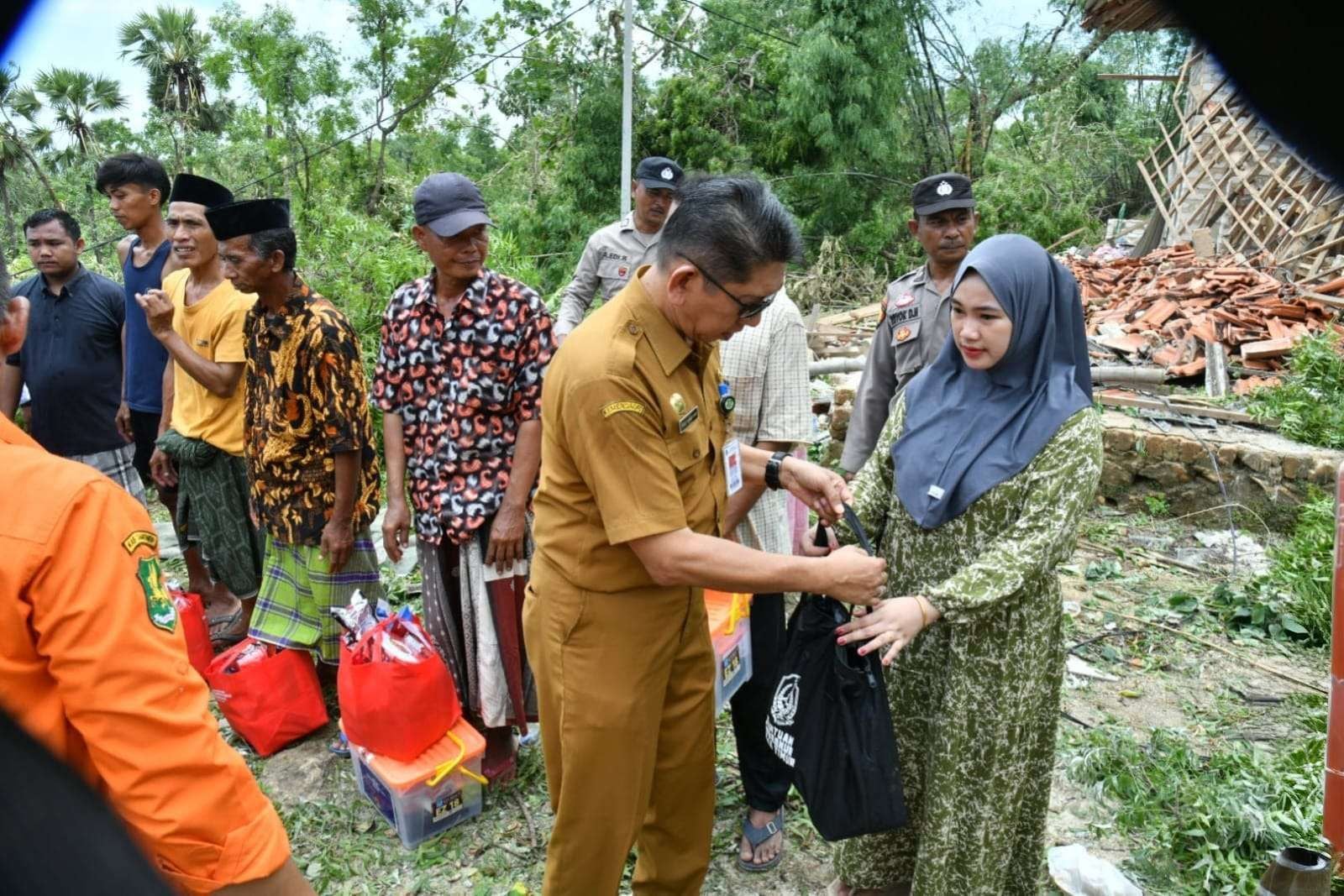 MELAYANI: Pj Sekkab Sumenep Syahwan Efendi saat memberikan bantuan kepada warga terdapat bencana di Desa Karduluk, Kecamatan Pragaan, Selasa (3/2).