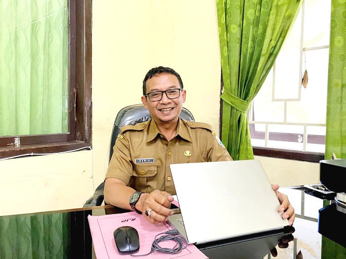 SANTAI: Kabid Linjamsos Dinsos PPPA Sampang Erwin Elmi Syarial saat ditemui di ruangannya Selasa (3/2). (AYU LATIFAH/JPRM)