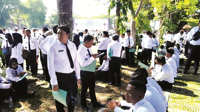 ABDI NEGARA: ASN PPPK paro waktu bersantai sebelum mengikuti pelantikan di Lapangan Nagara Bhakti Pamekasan, Rabu (17/12/2025). (M. KHOLIL RAMLI/JPRM)