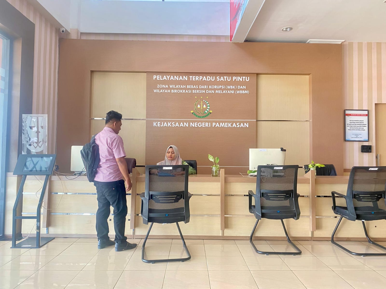 KELANJUTAN KASUS: Pelapor Achmad Salim menyerahkan berkas ke staf bagian resepsionis Kejari Pamekasan, Rabu (4/2).