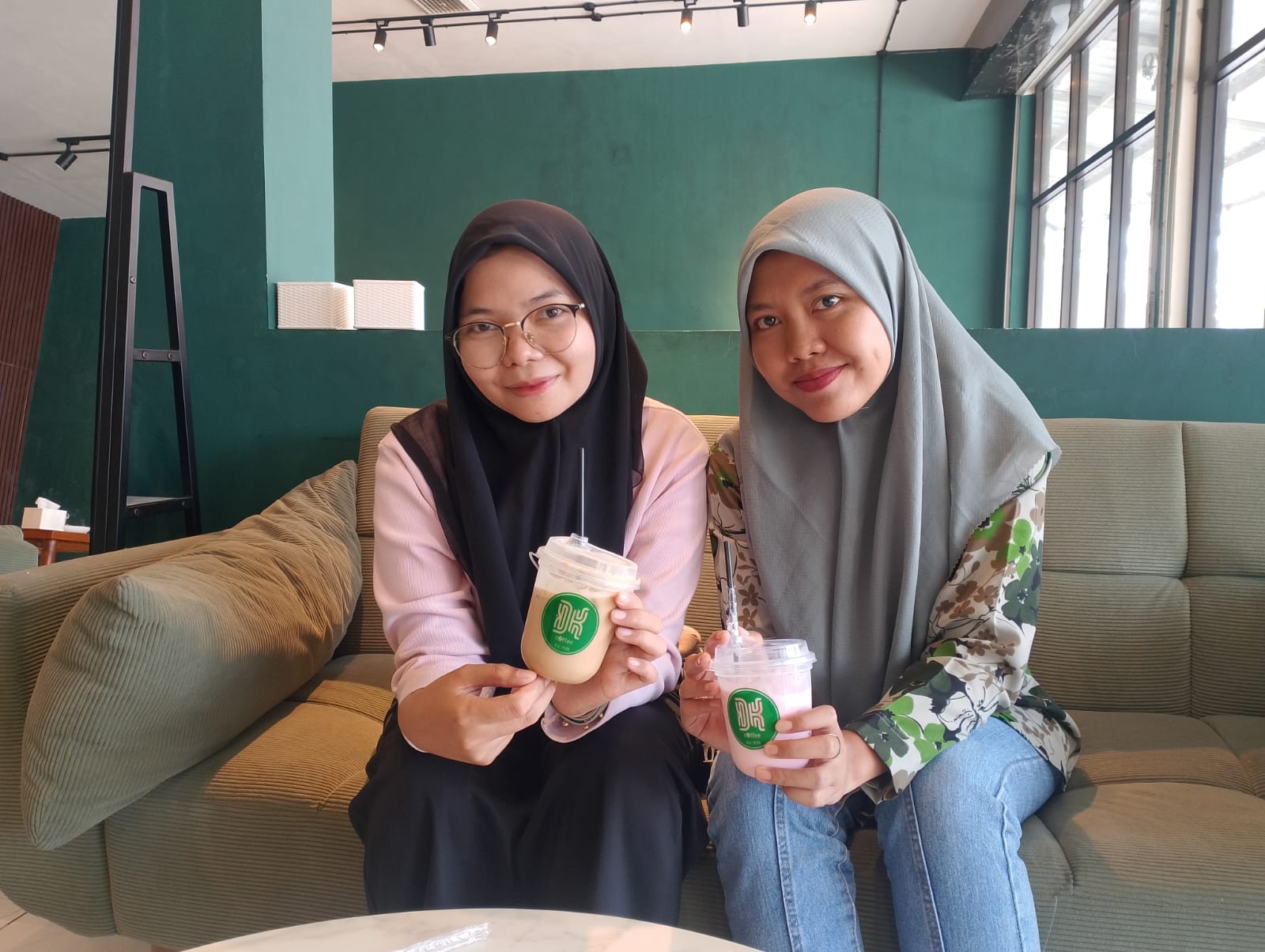 MENIKMATI: Putri (kiri) bersama rekannya menunjukkan minuman yang dipesannya di kafe DK Coffee & Resto, Jumat (6/2)