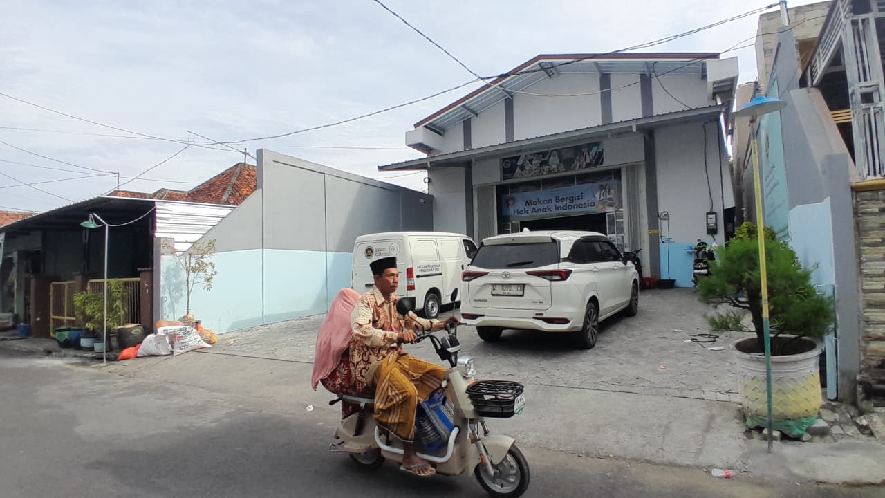 PROGRAM NASIONAL: Warga sedang melintas di depan SPPG Garuda Jaya Abadi di Jalan Ghazali Pamekasan, Sabtu (7/2).