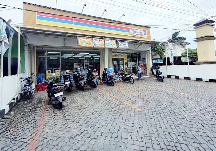 DIJAGA: Seorang jukir berada di depan toko modern di Perumahan Pondok Halim 2 Jalan Halim Perdanakusuma, Senin (9/2). (MUHAMMAD NAUFAL ABIYYU/JPRM)