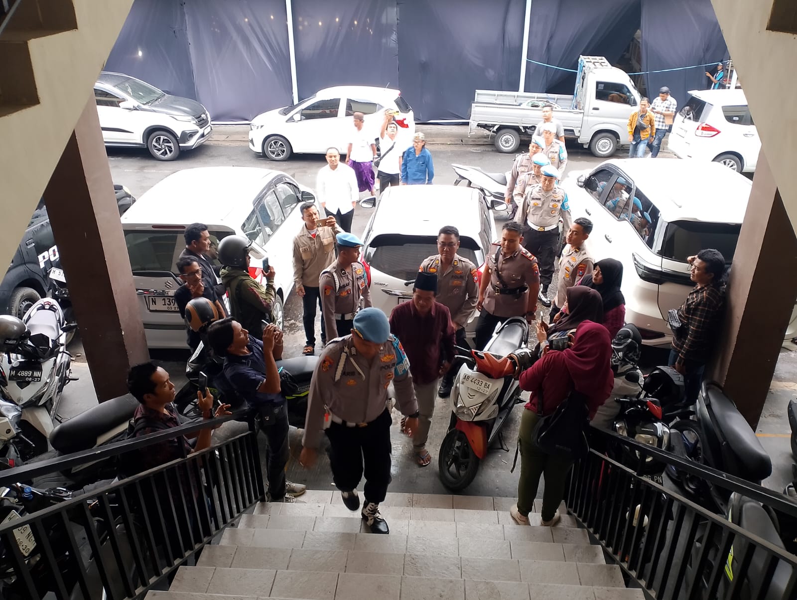 DIKAWAL KETAT: Mad Jari dikawal polisi saat menyerahkan diri ke Satreskrim Polres Sampang, Rabu (29/10/2025).