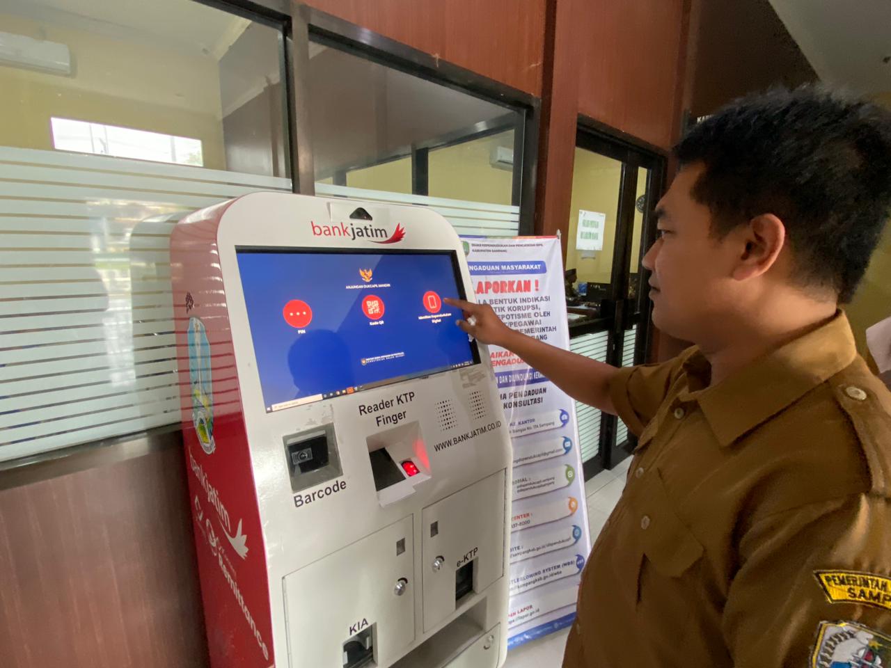 MELAYANI: Petugas mengecek fungsi ADM di kantor Disdukcapil Sampang, Senin (9/2).