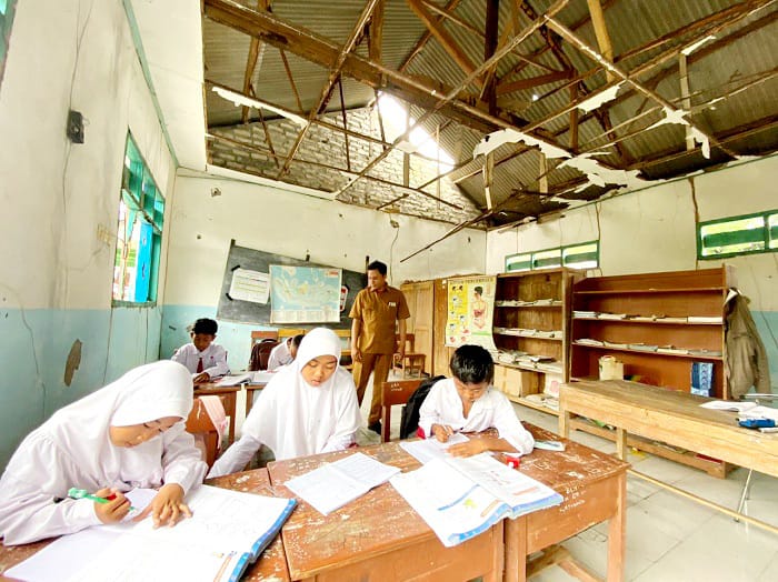 MEMPRIHATINKAN: Siswa kelas V saat belajar di ruang kelas yang bocor di SDN Margantoko 1, Kecamatan Jrengik, Sampang, Senin (9/2).&nbsp;(AYU LATIFAH/JPRM)