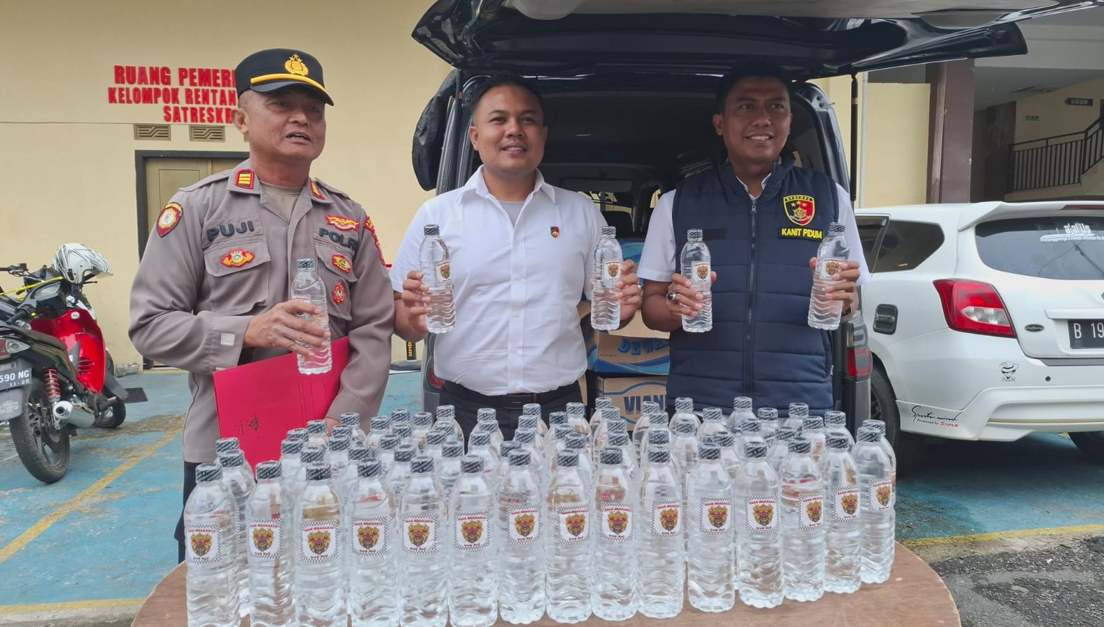 ILEGAL: PS Kasatreskrim Polres Sampang Iptu Fajri bersama anggotanya didampingi Kasihumas AKP Eko Puji Waluyo menunjukkan BB miras yang disita di halaman mapolres, Senin (9/2).