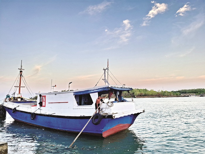 MENEPI: Nelayan berada di atas perahunya di Pelabuhan Kalianget, Sumenep, Jumat (9/1). (MOH. LATIF/JPRM)