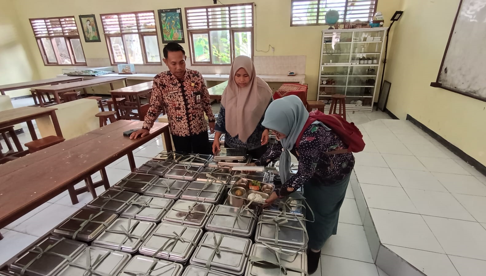 WASPADA: Guru SMAN 3 Bangkalan mengecek menu MBG sebelum diberikan kepada siswa Kamis (18/9/2025).