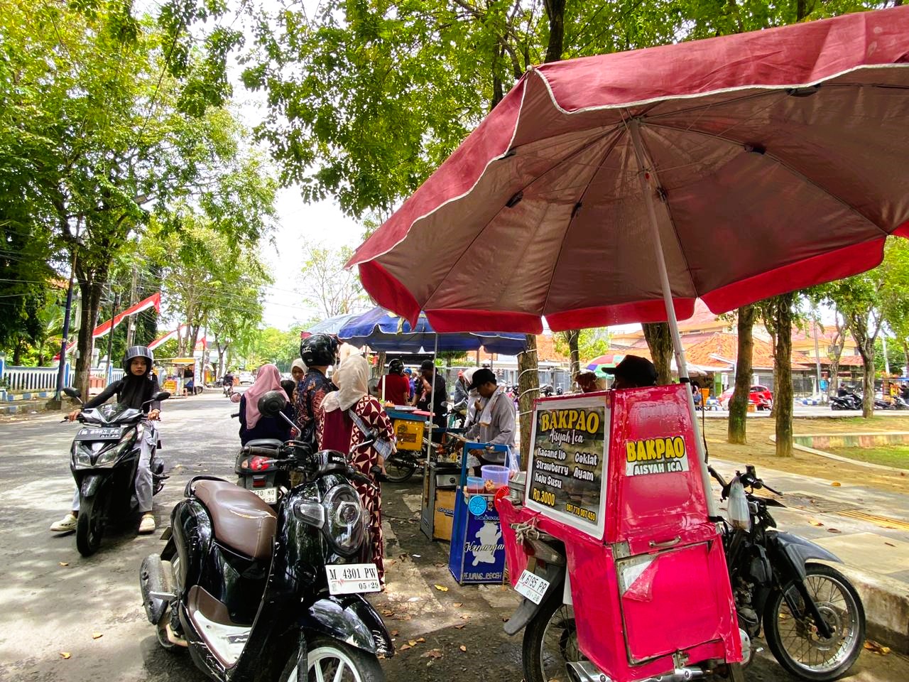 SANTAI: Para pelaku UMKM berjualan di sekitar Alun-Alun Trunojoyo Sampang, Senin (16/2).