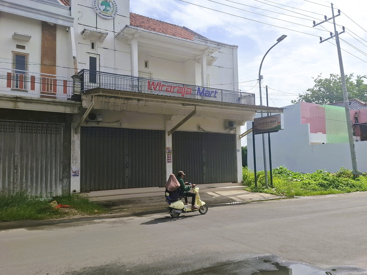 TUTUP: Masyarakat melintas di depan Koperasi Wiraraja Jalan Jokotole, Gedungan, Kecamatan Batuan, Sumenep, Senn (16/2).
