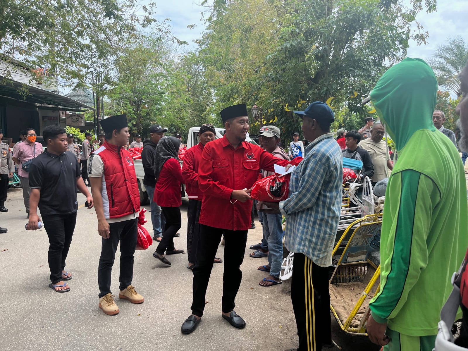 BERBAGI: Ketua DPC PDI Perjuangan Sumenep  saat menyerahkan bantuan berupa sembako dan uang tunai kepada abang becak di kawasan Jalan Ahmad Yani, Kelurahan Pajagalan, Kecamatan Kota Sumenep