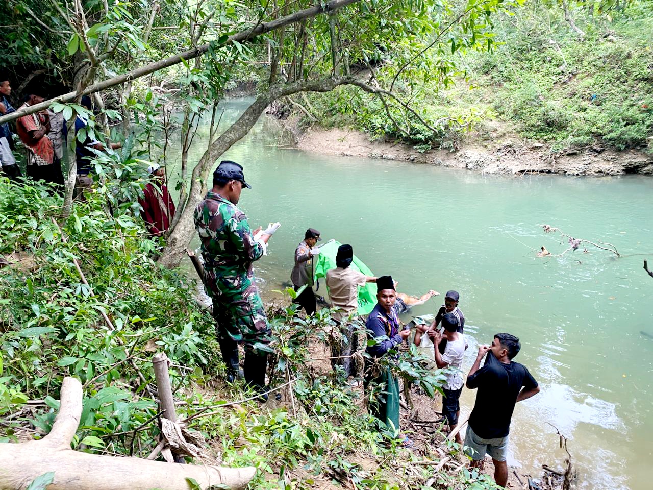 TANPA IDENTITAS: Warga bersama aparat kepolisian dan TNI mengevakuasi mayat yang ditemukan mengapung di Sungai Desa Tellok, Kecamatan Galis, Bangkalan, Sabtu (21/2). (POLSEK GALIS UNTUK JPRM)