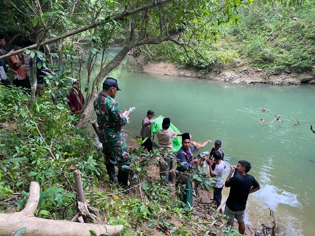 TANPA IDENTITAS: Warga bersama aparat kepolisian dan TNI mengevakuasi mayat yang ditemukan mengapung di sungai Desa Tellok, Kecamatan Galis, Bangkalan, Sabtu (21/2).