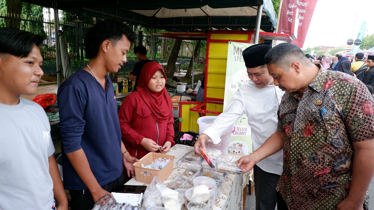 HUNTING MAKANAN: Direktur JPRM Abdul Aziz dan Sekkab Bangkalan Ismet Effendi mengunjungi salah satu peserta bazar takjil dari Kecamatan Galis yang turut memeriahkan berjualan di Bazar Takjil Ramadan.