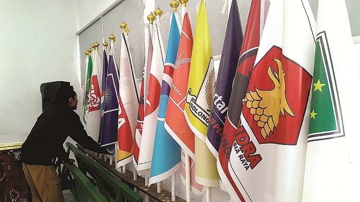 PESERTA PEMILU: Petugas KPU Pamekasan merapikan bendera parpol peserta Pemilu 2024, Selasa (6/1). (M. KHOLIL RAMLI/JPRM)