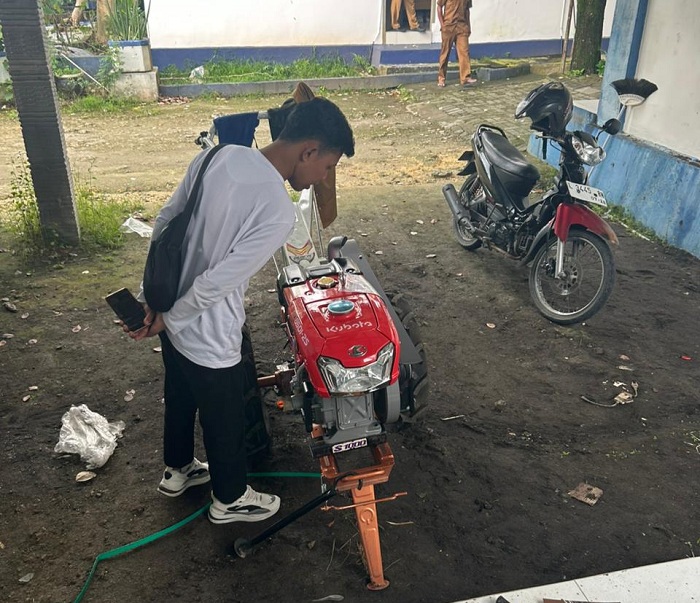 DIGANTI: Pegawai Disperta KP Sampang berada di sekitar mesin hand tractor yang baru dipasang Senin (23/2). (UBAIDILLAHIR RAIE/JPRM)