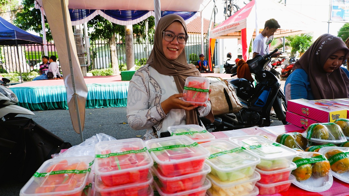 SEHAT: Intan menunjukkan buah-buahan segar yang dijual di Bazar Takjil Ramadan, Bangkalan, Minggu (22/2).