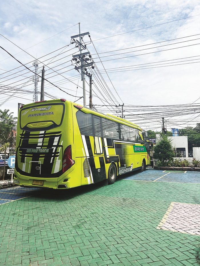 DILIMPAHKAN: Pengendara sepeda motor melintas di sisi utara bus pengangkut rokok ilegal di halaman kantor Kejari Sampang Rabu (25/2). (UBAIDILLAHIR RAIE/JPRM)