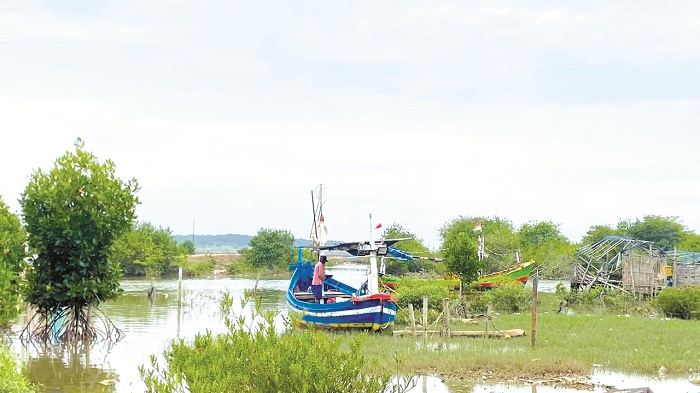 DITAMBATKAN: Seorang nelayan sedang membersihkan perahu di Kampung Juklanteng, Kelurahan Banyuanyar, Sampang, Selasa (24/2). (AYU LATIFAH/JPRM)