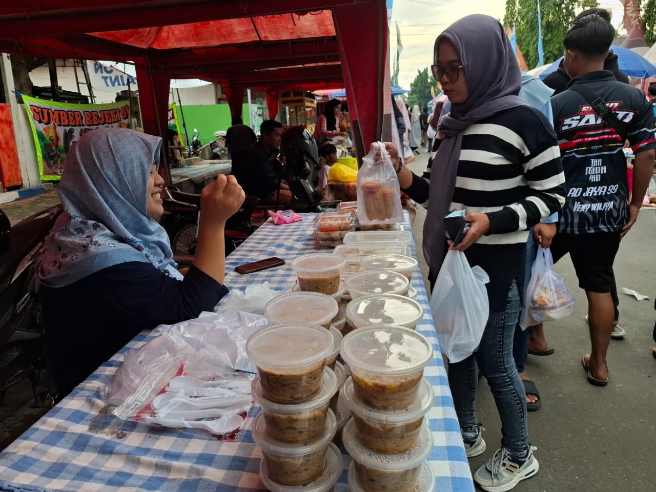 LARIS: Ruhanniyah melayani pembeli di stan Bazar Takjil Ramadan di Jalan dr Soetomo, Pajagalan, Kecamatan Kota Sumenep,&nbsp;Rabu (25/2)