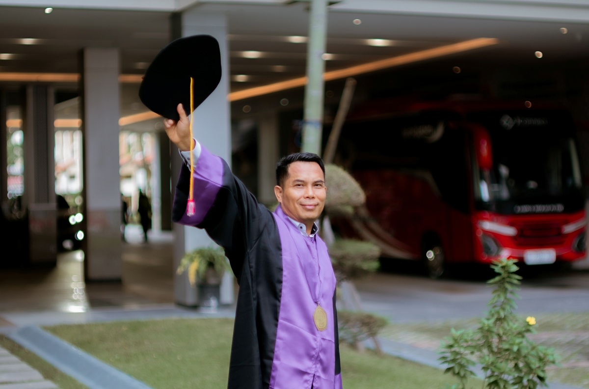BERPENDIDIKAN: Sekretaris Bakesbangpol Sumenep Edy Suprayitno berpose menggunakan toga usai wisuda di Untag Surabaya, Sabtu (14/2).