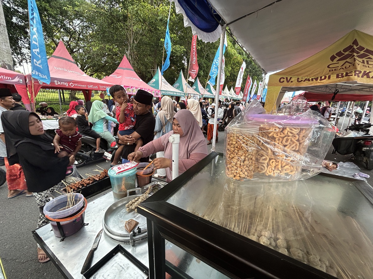 LARIS: Melani saat melayani pembeli sate-satean di stan bazar takjil, Rabu (25/2).