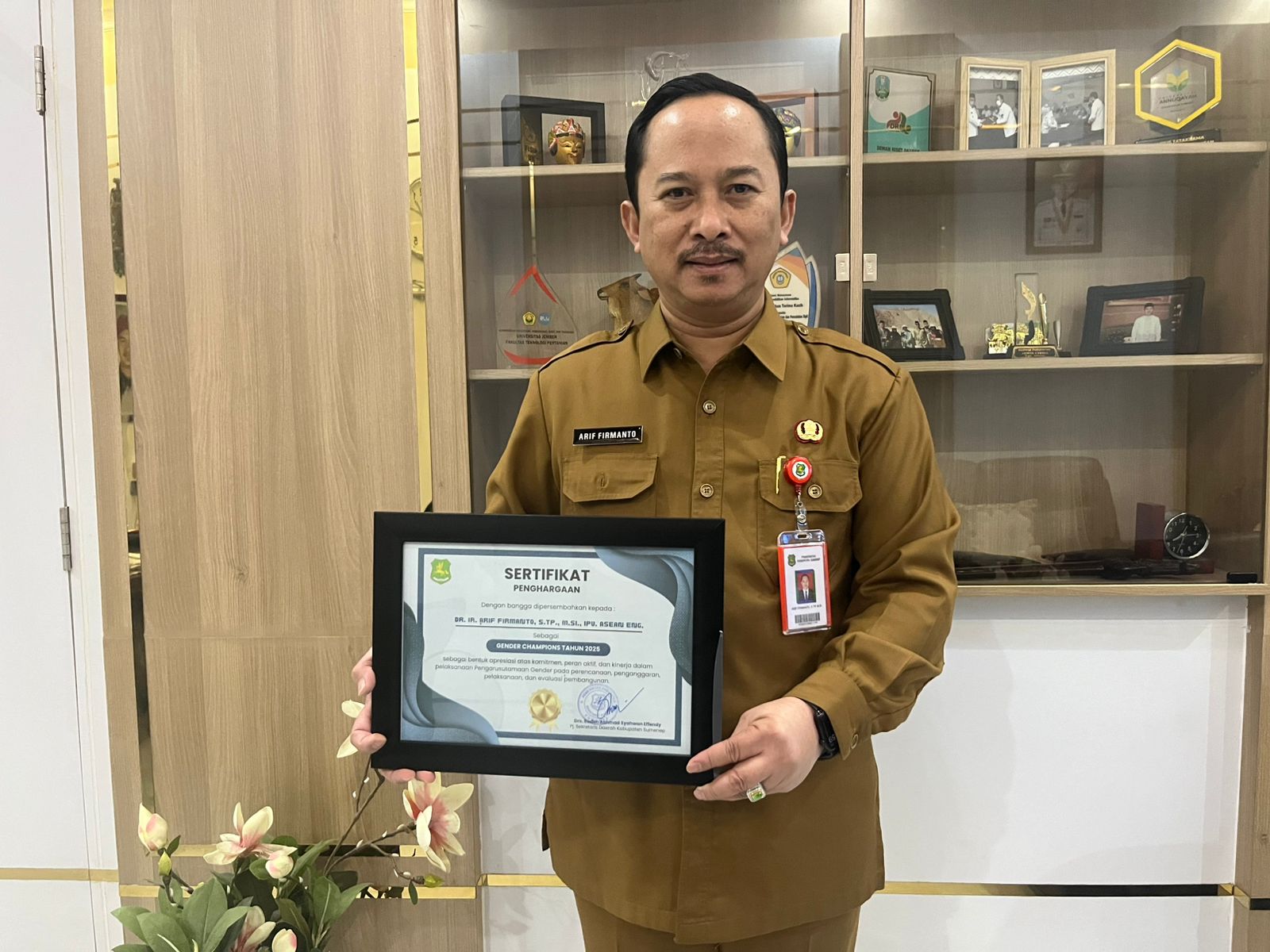 MEMBANGGAKAN: Kepala Bappeda Sumenep Arif Firmanto memegang sertifikat penghargaan Gender Champions 2025 yang diterimanya dari Pemkab Sumenep di ruang kerjanya pada Senin (23/2).