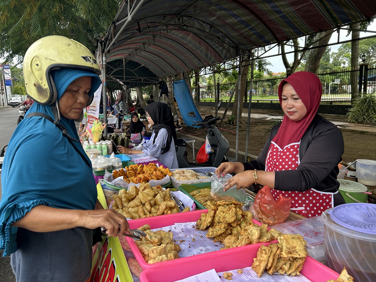 LARIS: Ima melayani pembeli di lapak jualannya di Bazar Takjil Ramadan, Bangkalan, Kamis (26/2).