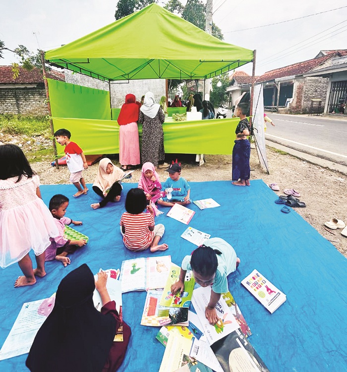 LITERASI: Sejumlah anak belajar di samping bazar takjil di Desa Daleman, Kecamatan Kedungdung, Sampang, Sabtu (28/2). (FAUZAN UNTUK JPRM)
