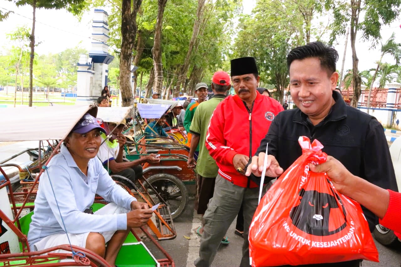 PENUH MAKNA: Iwan Effendi (baju hitam) saat berbagai sembako dengan kaum duafa di Kota Sampang bebrapa waktu lalu.
